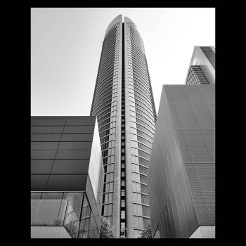 Contrapicado de la torre PWC de Madrid en blanco y negro junto a otros elementos de la zona de negocios