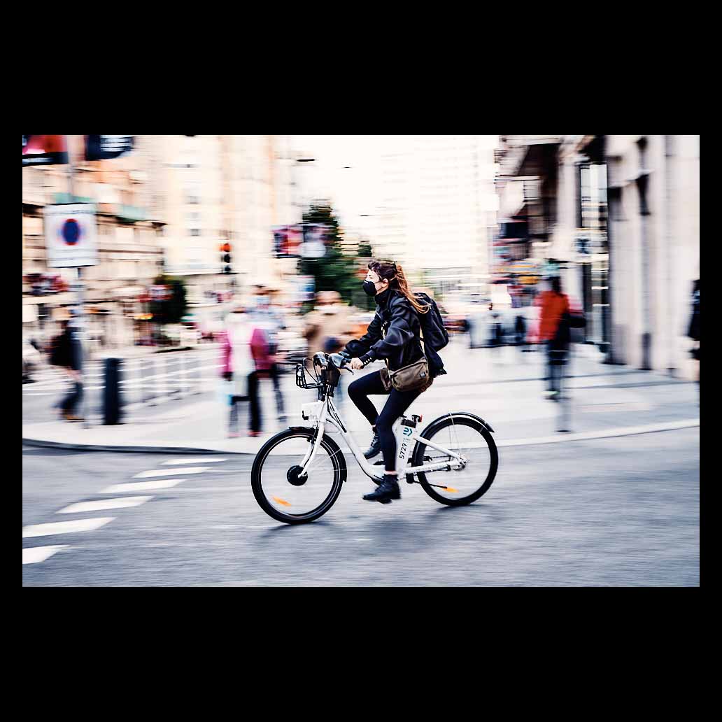 Panning de una ciclista circulando por la Gran Vía de Madrid