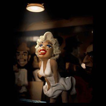 Pequeña escultura de Marilyn Monroe con su vestido blanco bajo la luz de un foco