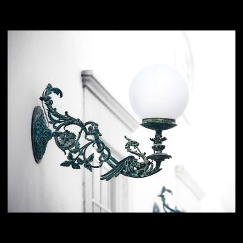 Una bonita lámpara artesana en fachada con filigrana de dragón, para iluminar la calle