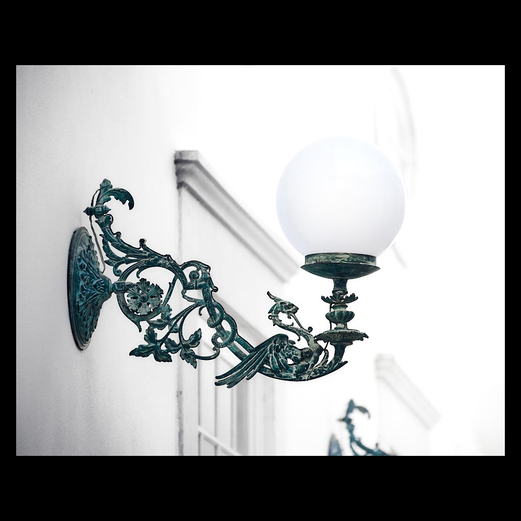 Una bonita lámpara artesana en fachada con filigrana de dragón, para iluminar la calle