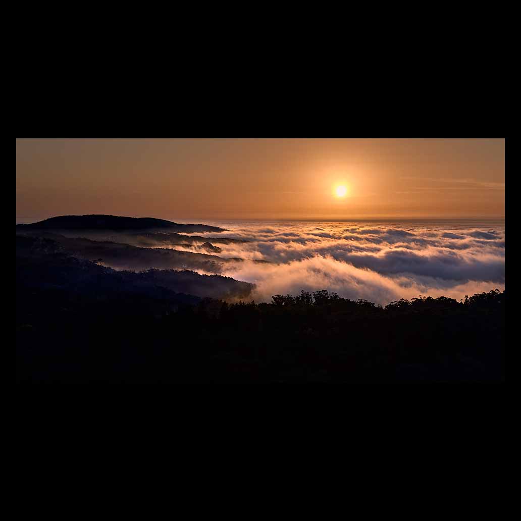 Atardecer sobre un gran mar de nubes que reflejan la luz dorada del sol