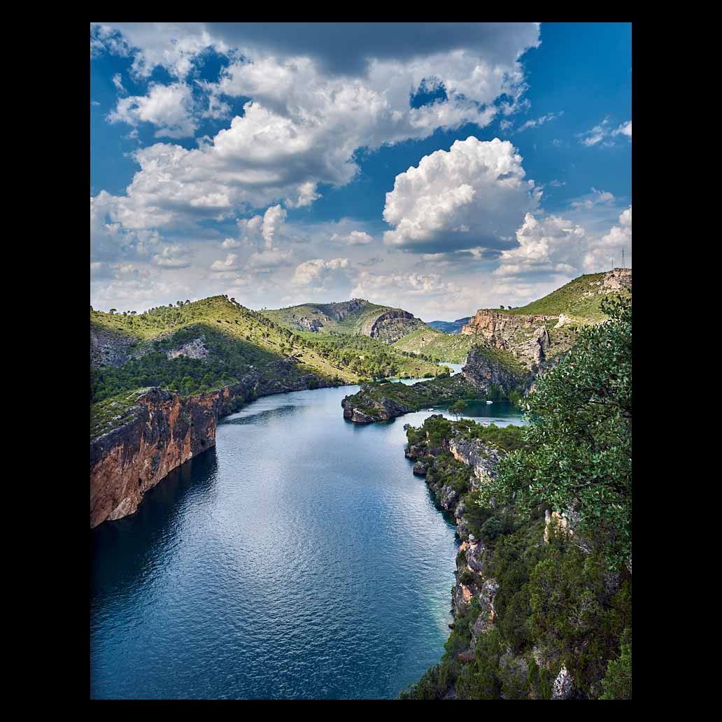 Embalse de Bolarque bajo un cielo azul precioso con grandes nubes blancas reflejan la luz del sol