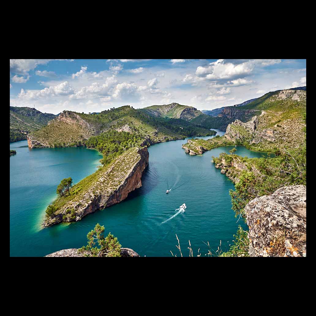 Embalse de Bolarque en un día espléndido con cielo azul y grandes nubes blancas que hacen sombra sobre el paisaje