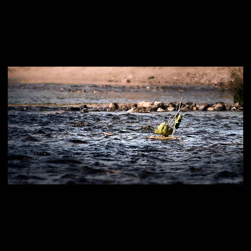 Velero hecho de hojas y cañas navega por la corriente de un río