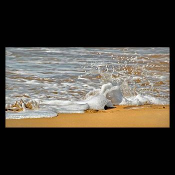 Sea foam breaks on the beach