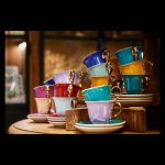 Tazas de café de colores llamativos y con asas doradas