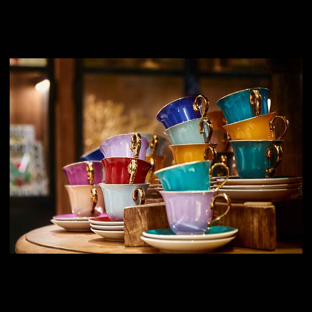 Tazas de café de colores llamativos y con asas doradas