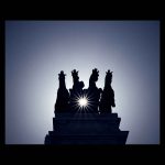 Las cuadrigas de la calle Alcalá de Madrid en contraluz con una "sun stars" entre medias