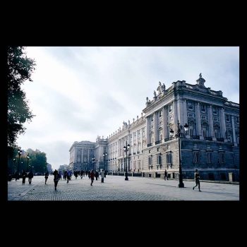 Palacio Real de Madrid iluminado por la luz que se escapa entre las nubes