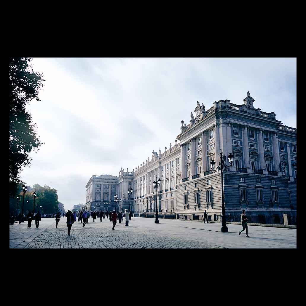 Palacio Real de Madrid iluminado por la luz que se escapa entre las nubes