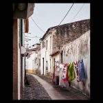 Calle de pueblo con suelo empedrado y ropa tendida con colores llamativos