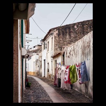 Calle de pueblo con suelo empedrado y ropa tendida con colores llamativos