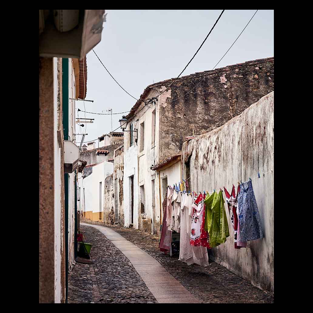 Calle de pueblo con suelo empedrado y ropa tendida con colores llamativos