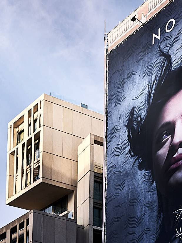 Fachada singular en la Gran Vía de madrid junto a cartel publicitario