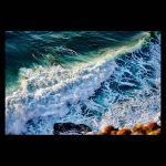 Olas rompiendo en el acantilado al atardecer