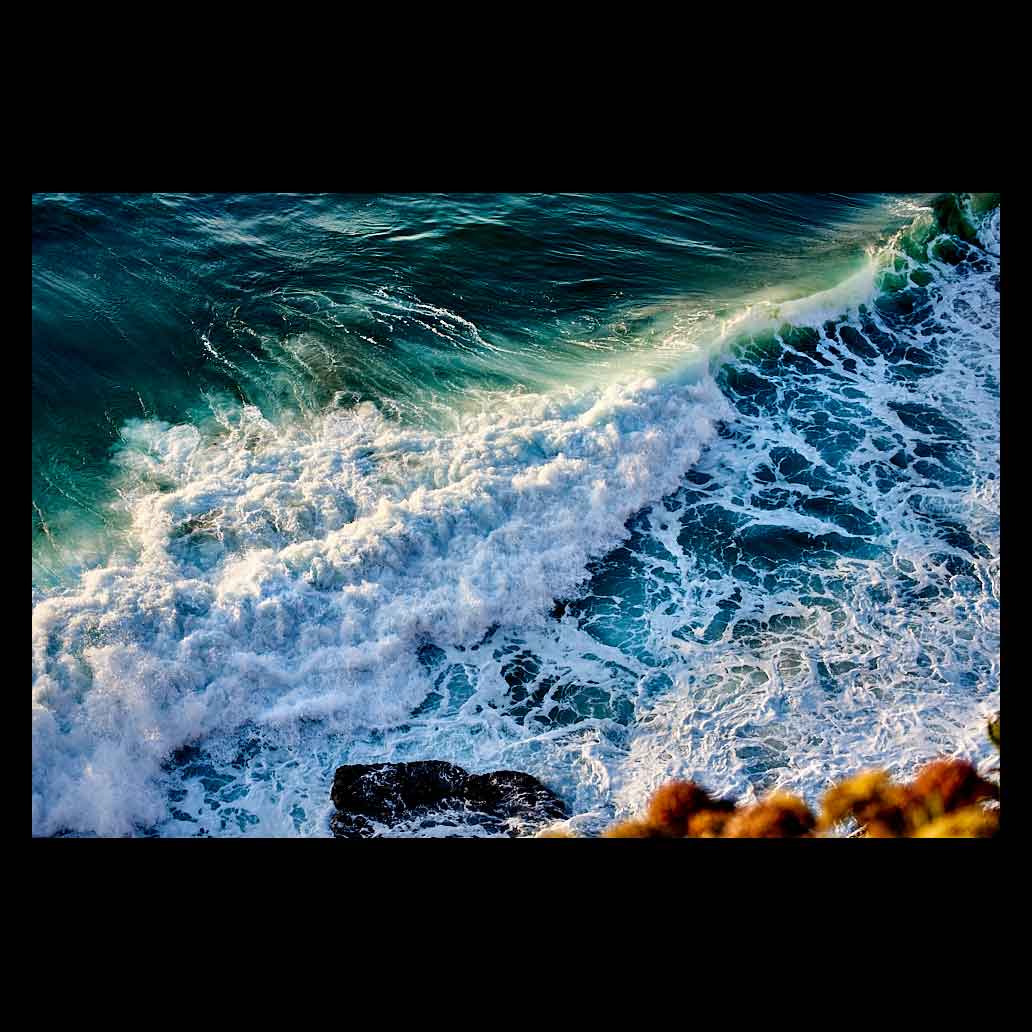 Olas rompiendo en el acantilado al atardecer